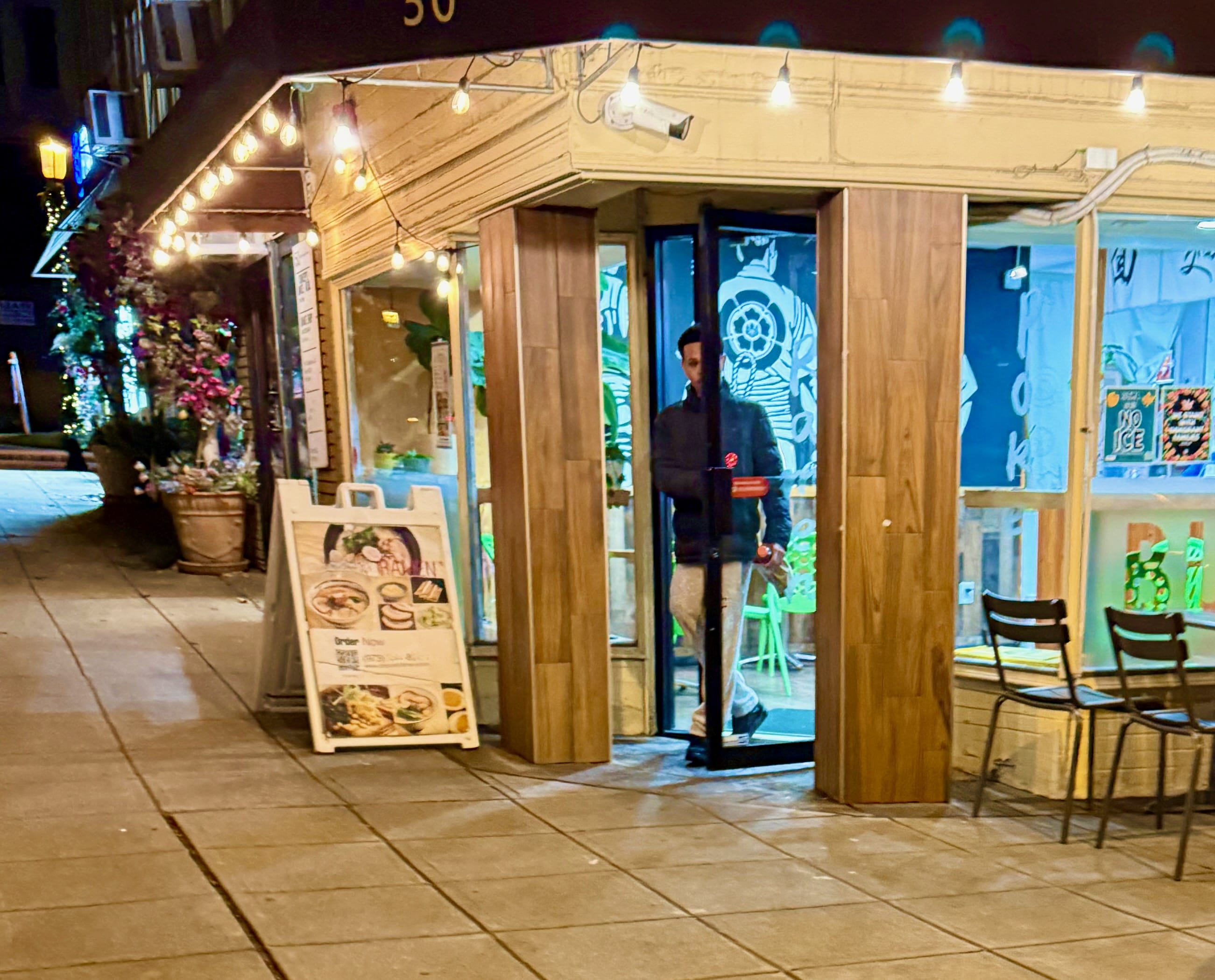 A man walks out of a restaurant.jpeg